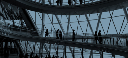 Image shows people walking on the spiral staircase of London City Hall with views of the Thames through the diamond shaped windows. A slate-blue colour wash covers the image. Indicates Serving customers.